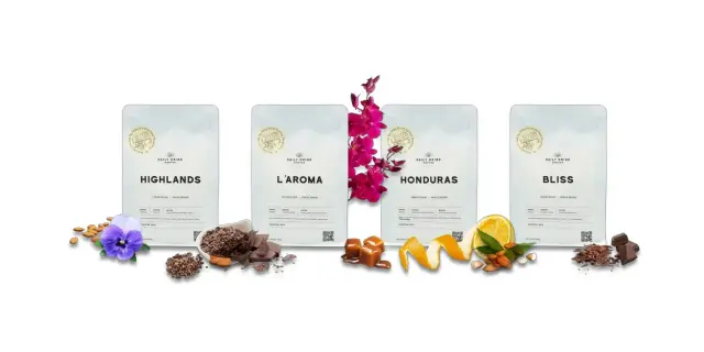 Four Daily Grind coffee bags, Highlands, L'aroma, Honduras and Bliss, each with a roasting date field on the label