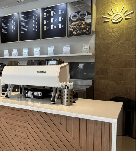 Daily Grind counter with the sun logo on the wall