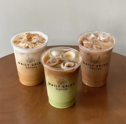 Three iced lattes on a wooden table